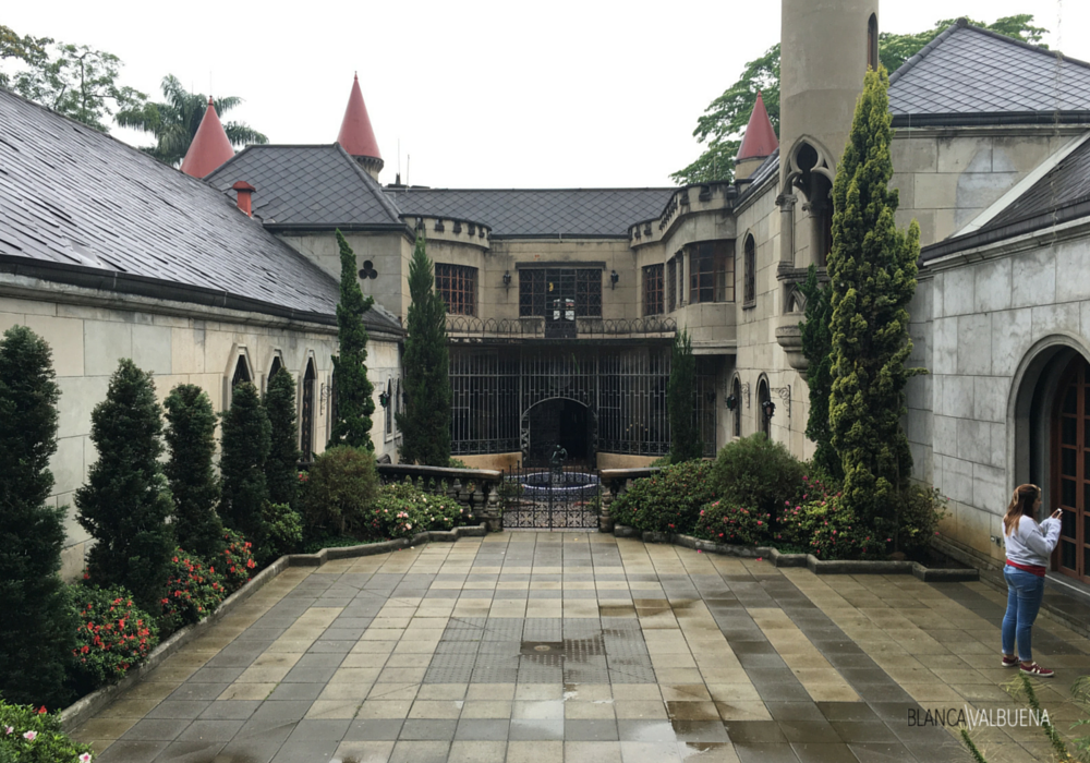 The back of the house shows a deck, fountain and Chateauesque details